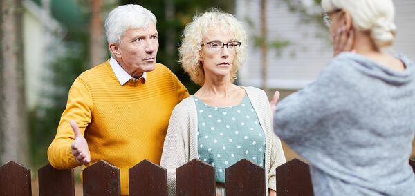 un couple de personnes âgées discute âprement avec une voisine